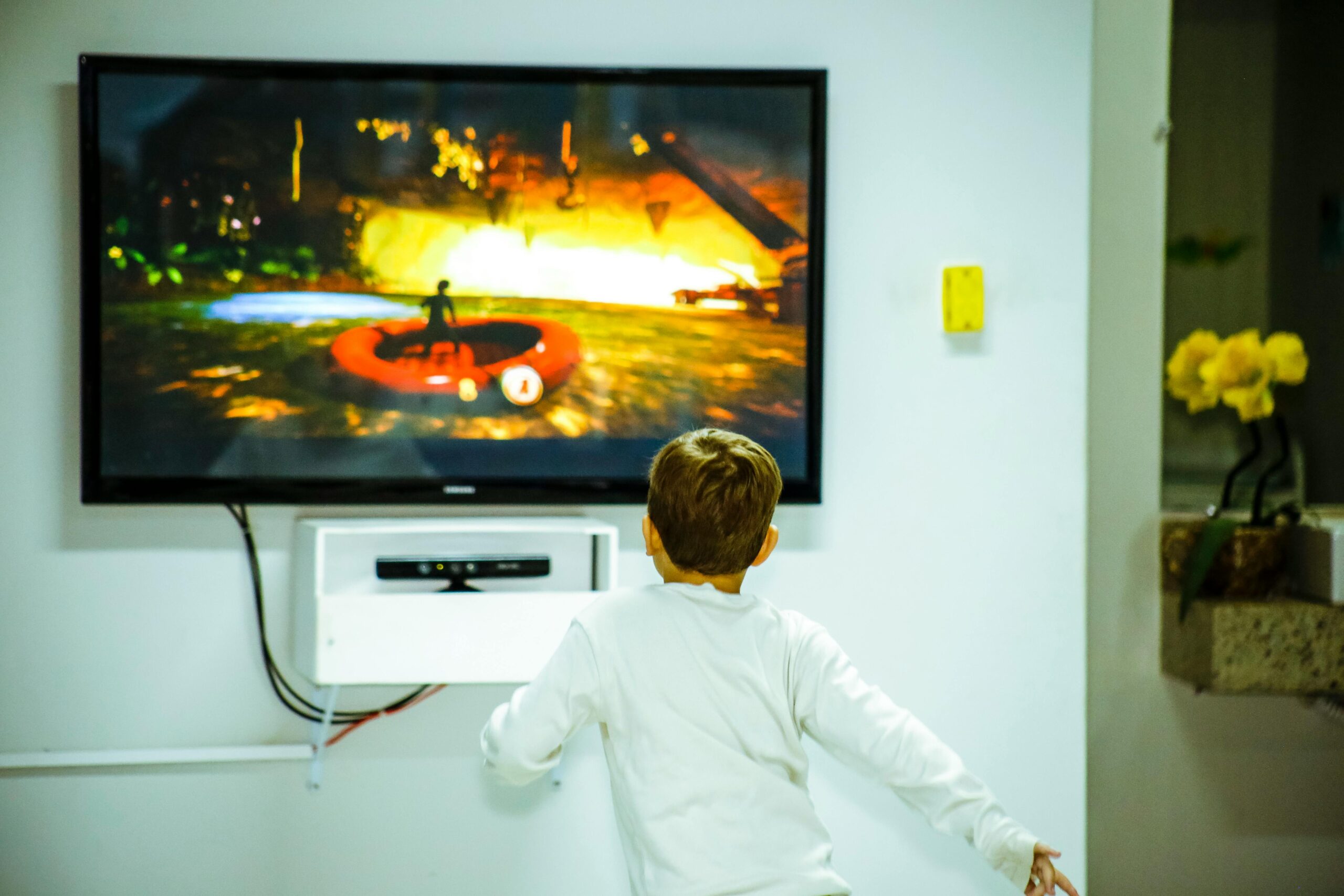 A young boy intensely watching and interacting with a video game on a television screen indoors.